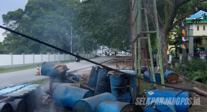
 Sejumlah drum berisi material minyak untuk kebutuhan proses produksi hotmix terlihat berada di tepi jalan lokasi proyek peningkatan Jalan Panggaram, Kelurahan Selatpanjang Kota, Kecamatan Tebing Tinggi, Kepulauan Meranti, Senin (05/8/2026).